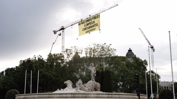 Escaladores de Greenpeace despliegan una pancarta junto al Congreso para exigir que no se destine más dinero público a empresas contaminantes