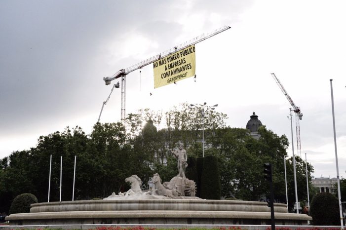 Escaladores de Greenpeace despliegan una pancarta junto al Congreso para exigir que no se destine más dinero público a empresas contaminantes