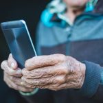 Old hands hold smart phone