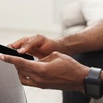 Closeup of male hands using smartphone with blank screen