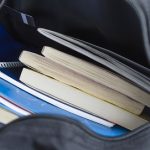 Backpack with schoolbooks and notebooks. Education concept image. Selective focus