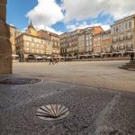 Urban landscape photography in Plaza Mayor, in Ourense, with the symbol of Santiago de Compostela walkers in the foreground.